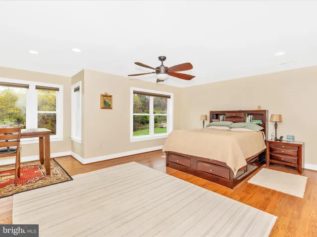 a bedroom with a bed and a table with wooden floor