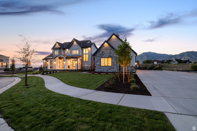 115 East Hidden Ridge Lane, Unit 42 Mapleton, UT 84664 - Photo 99 of 103 Stately residence featuring a stone and stucco exterior, multiple gables, a covered entry porch with columns, a curved concrete pathway, and a wide concrete driveway