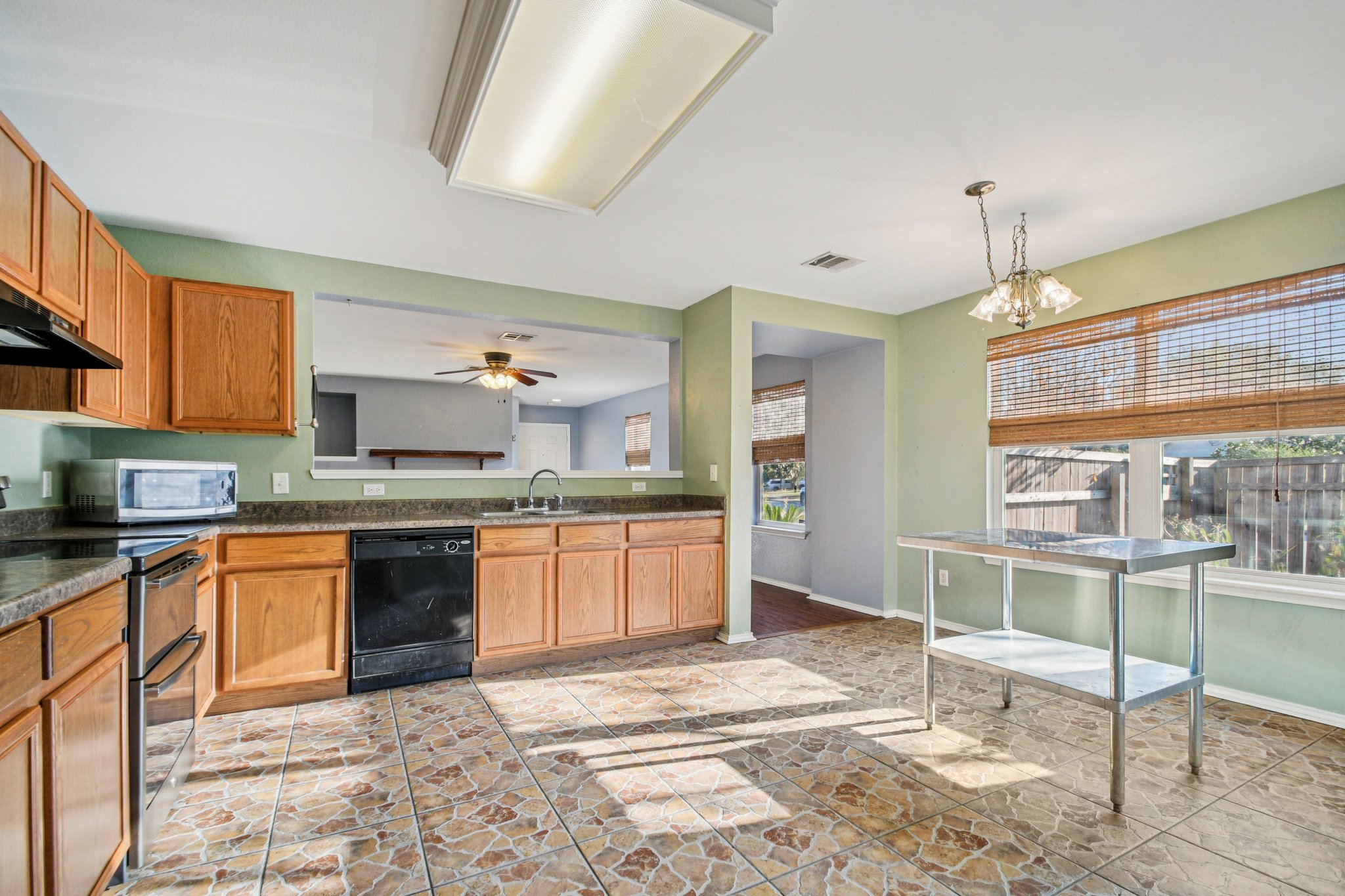 100 Kendall Cove Elgin, TX 78621 - Photo 12 of 31 a kitchen with stainless steel appliances granite countertop a stove top oven a sink dishwasher and a wooden cabinets