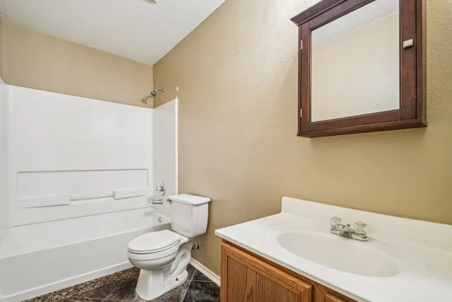 a bathroom with a sink toilet and mirror