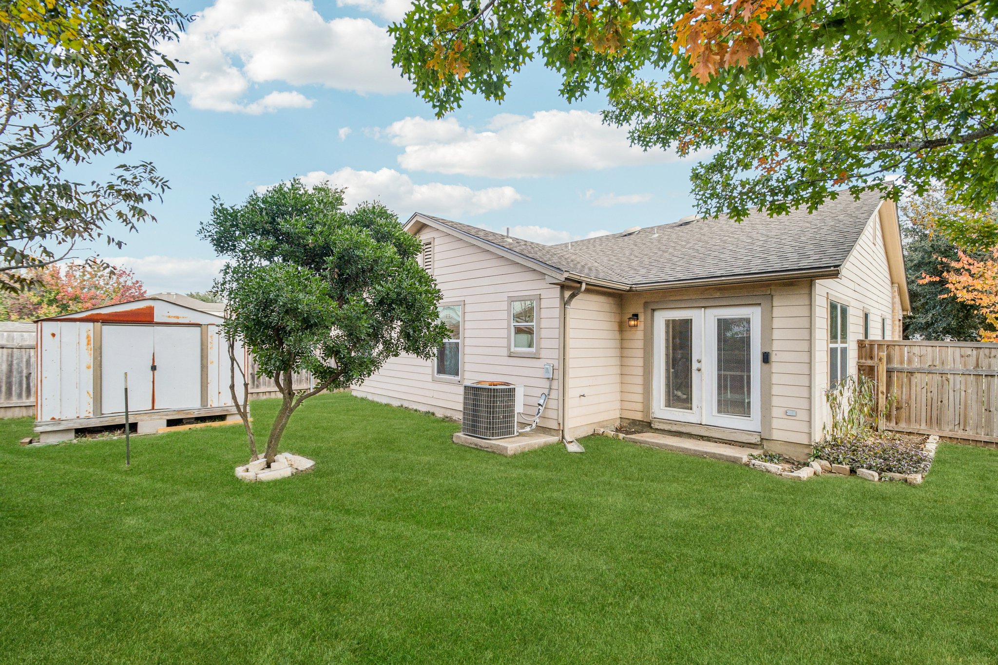 100 Kendall Cove Elgin, TX 78621 - Photo 27 of 31 a view of a house with backyard and a tree