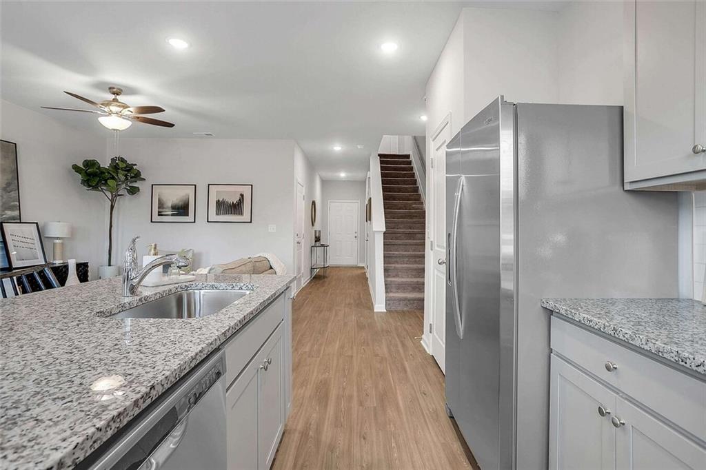 10 American Avenue, Unit ANISE Newnan, GA 30263 - Photo 4 of 47 a kitchen with granite countertop a sink and refrigerator