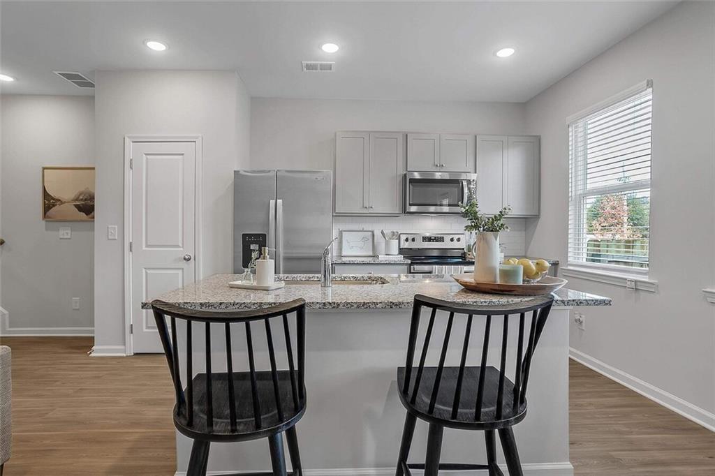 10 American Avenue, Unit ANISE Newnan, GA 30263 - Photo 8 of 47 a kitchen with stainless steel appliances a microwave a stove a sink dishwasher and a refrigerator