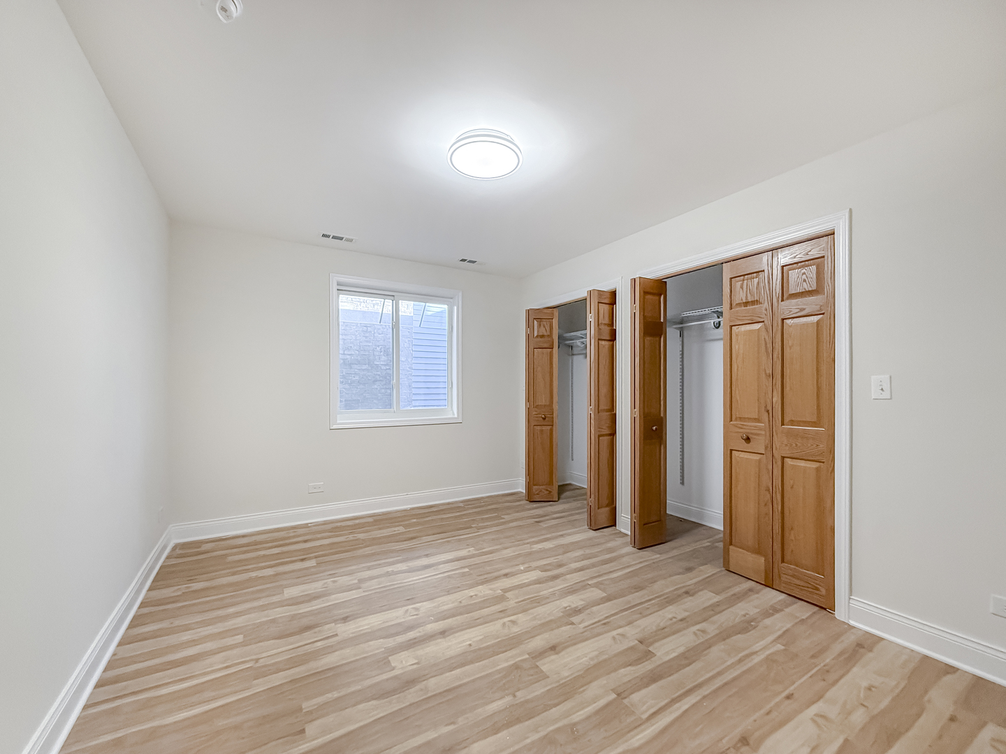 6415 West Irving Park Road, Unit 2N Chicago, IL 60634 - Photo 11 of 16 an empty room with wooden floor and windows