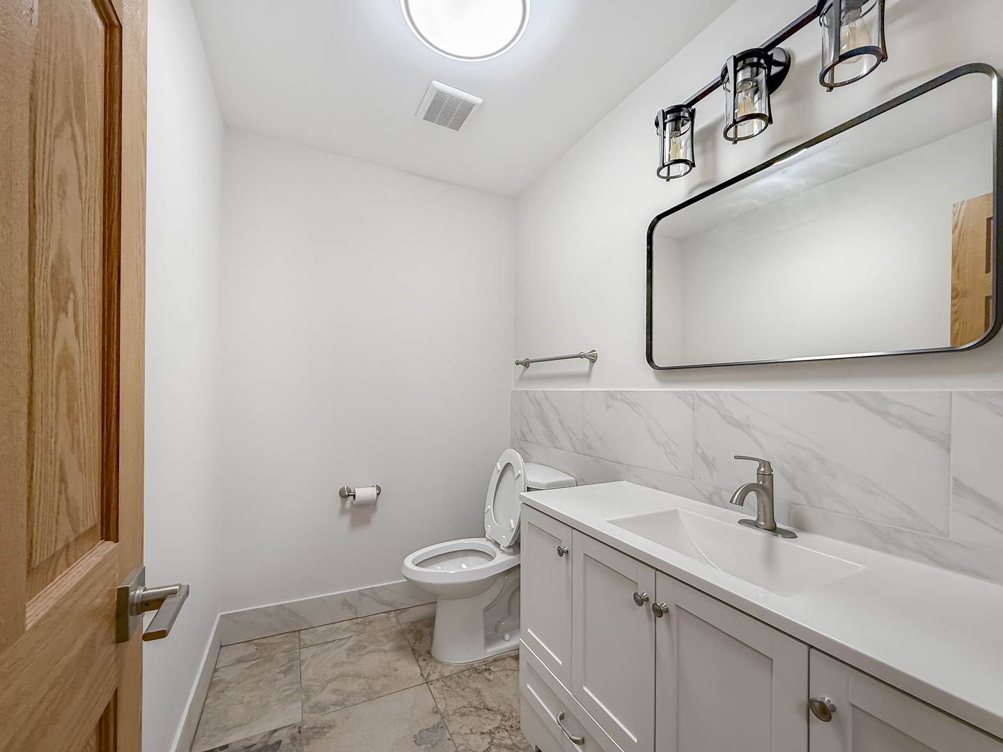 6415 West Irving Park Road, Unit 2N Chicago, IL 60634 - Photo 8 of 16 a bathroom with a toilet sink and mirror