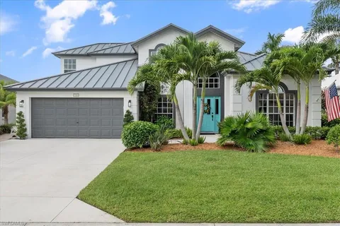 a front view of a house with a yard and potted plants