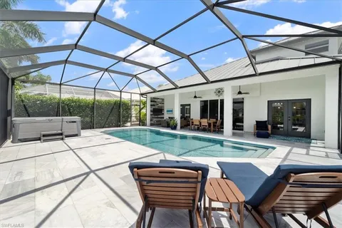 a view of a backyard with table and chairs under an umbrella
