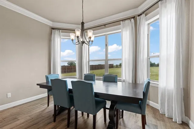 a kitchen with stainless steel appliances kitchen island granite countertop a refrigerator a sink dishwasher a oven and a dining table with wooden floor