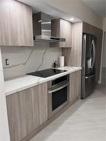 a kitchen with stainless steel appliances a stove a sink and a refrigerator
