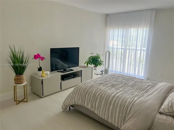 a bedroom with a bed and a flat screen tv
