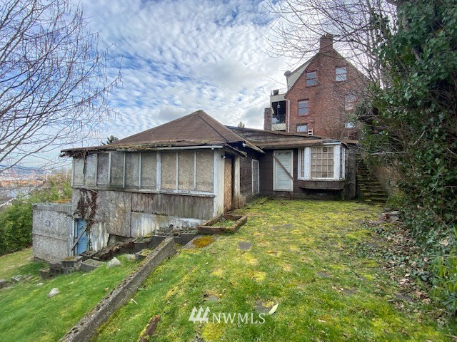 1701 41st Avenue Southwest Seattle, WA 98116 - Photo 16 of 21 a view of a house with a yard plants and large tree