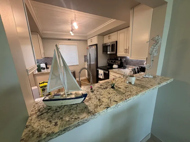 a kitchen with stainless steel appliances granite countertop a stove a sink and a refrigerator