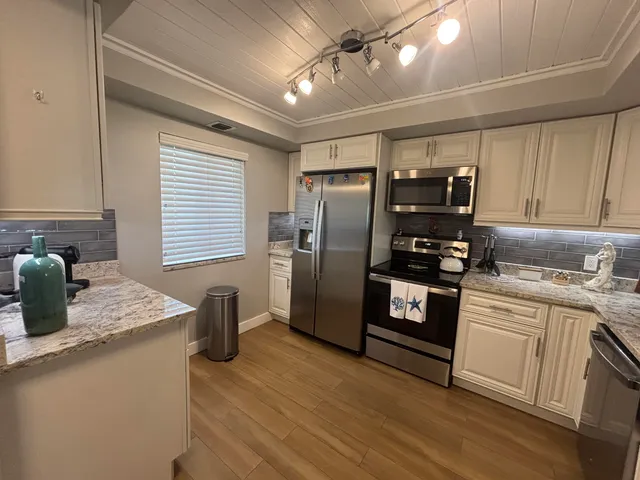 a kitchen with granite countertop a sink a stove and cabinets
