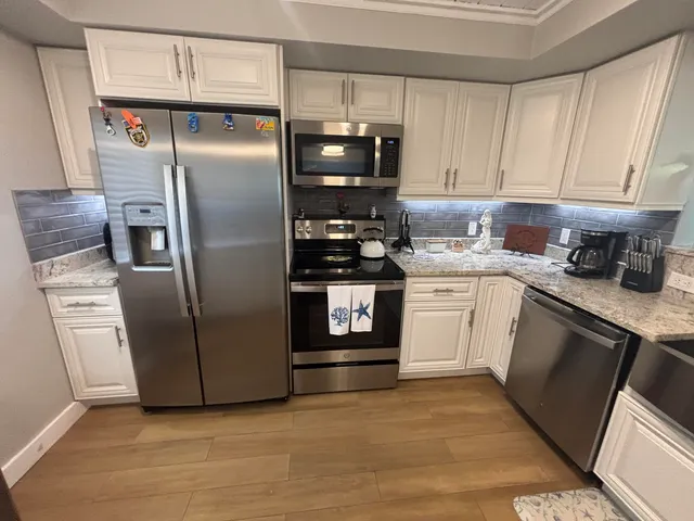 a kitchen with stainless steel appliances granite countertop a sink and a stove