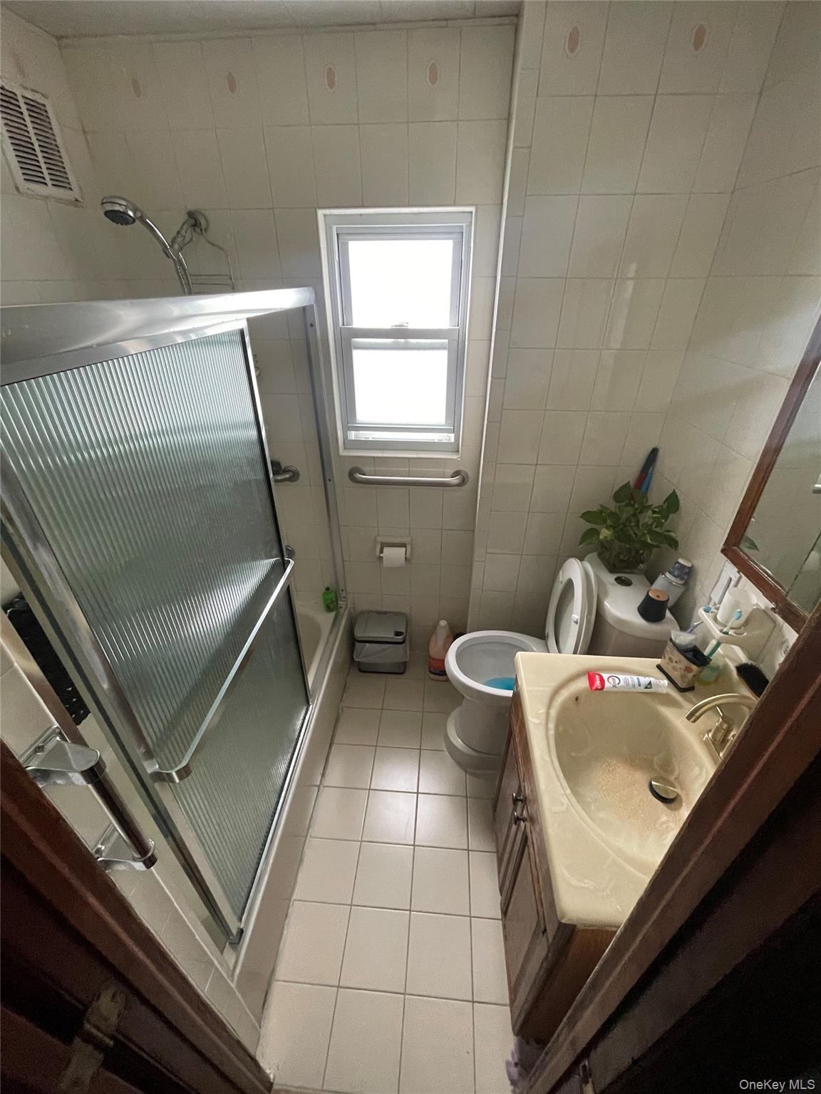 106-20 109th Avenue Queens, NY 11417 - Photo 6 of 12 Bathroom featuring a stall shower, vanity, tile walls, and light tile patterned flooring