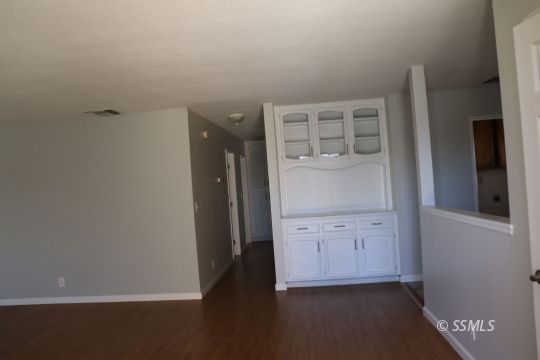 329 Lenore Street Ridgecrest, CA 93555 - Photo 2 of 28 an empty room with wooden floor and cabinet