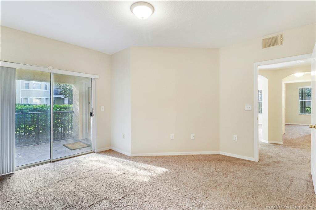 110 Southwest Peacock Boulevard, Unit 6104 Port St. Lucie, FL 34986 - Photo 16 of 27 an empty room with floor to ceiling windows