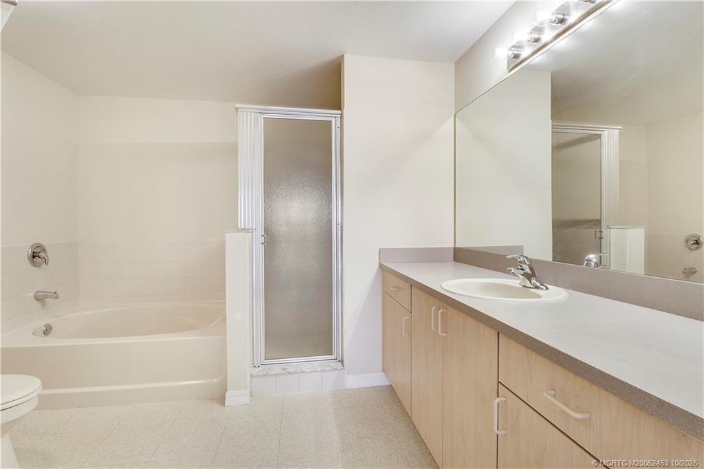 110 Southwest Peacock Boulevard, Unit 6104 Port St. Lucie, FL 34986 - Photo 18 of 27 a bathroom with a granite countertop sink and a mirror