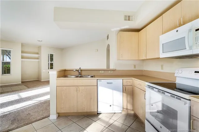a kitchen with a stove sink and cabinets
