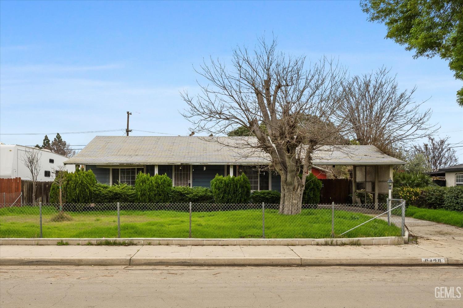 Undisclosed Address Bakersfield, CA 93308 - Photo 3 of 50 a view of a brick house with a big yard plants and large trees