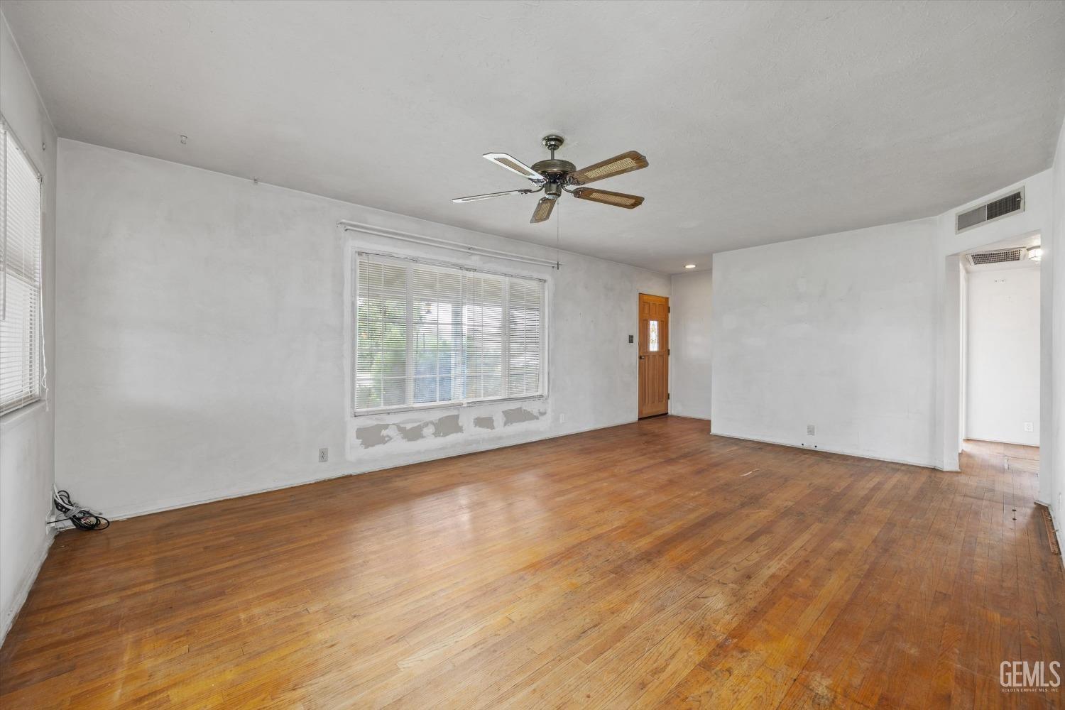 Undisclosed Address Bakersfield, CA 93308 - Photo 9 of 50 a view of empty room with wooden floor and ceiling fan