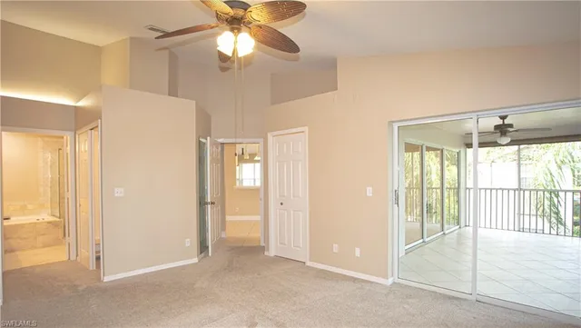 an empty room with closet and a chandelier fan