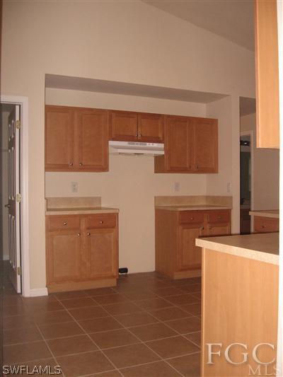 1900 West 13th Street Lehigh Acres, FL 33972 - Photo 3 of 10 a kitchen with a sink dishwasher and a refrigerator