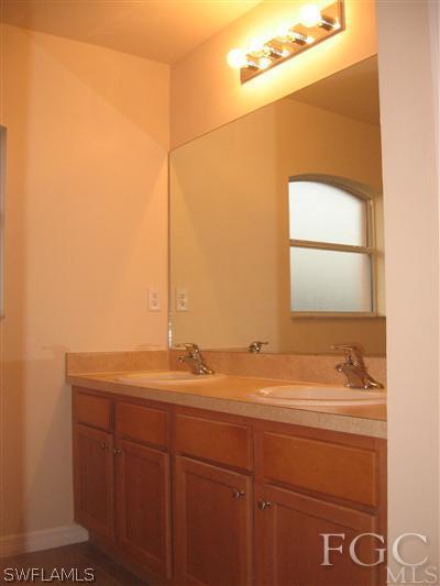 1900 West 13th Street Lehigh Acres, FL 33972 - Photo 7 of 10 a bathroom with a sink and a mirror