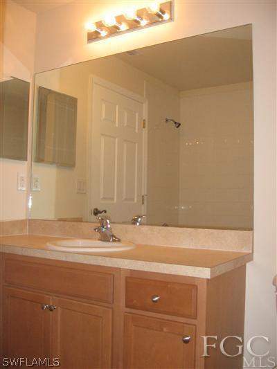 1900 West 13th Street Lehigh Acres, FL 33972 - Photo 8 of 10 a bathroom with a sink and a mirror