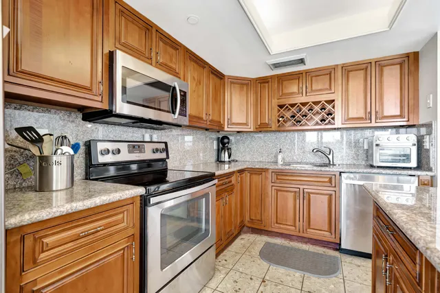 a kitchen with stainless steel appliances granite countertop a sink stove and cabinets