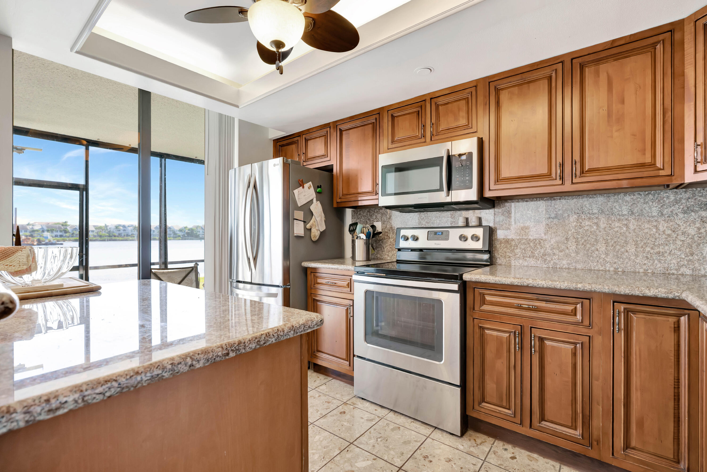 1542 Jupiter Cove Drive, Unit 104 Jupiter, FL 33469 - Photo 14 of 65 a kitchen with stainless steel appliances granite countertop a stove microwave and cabinets