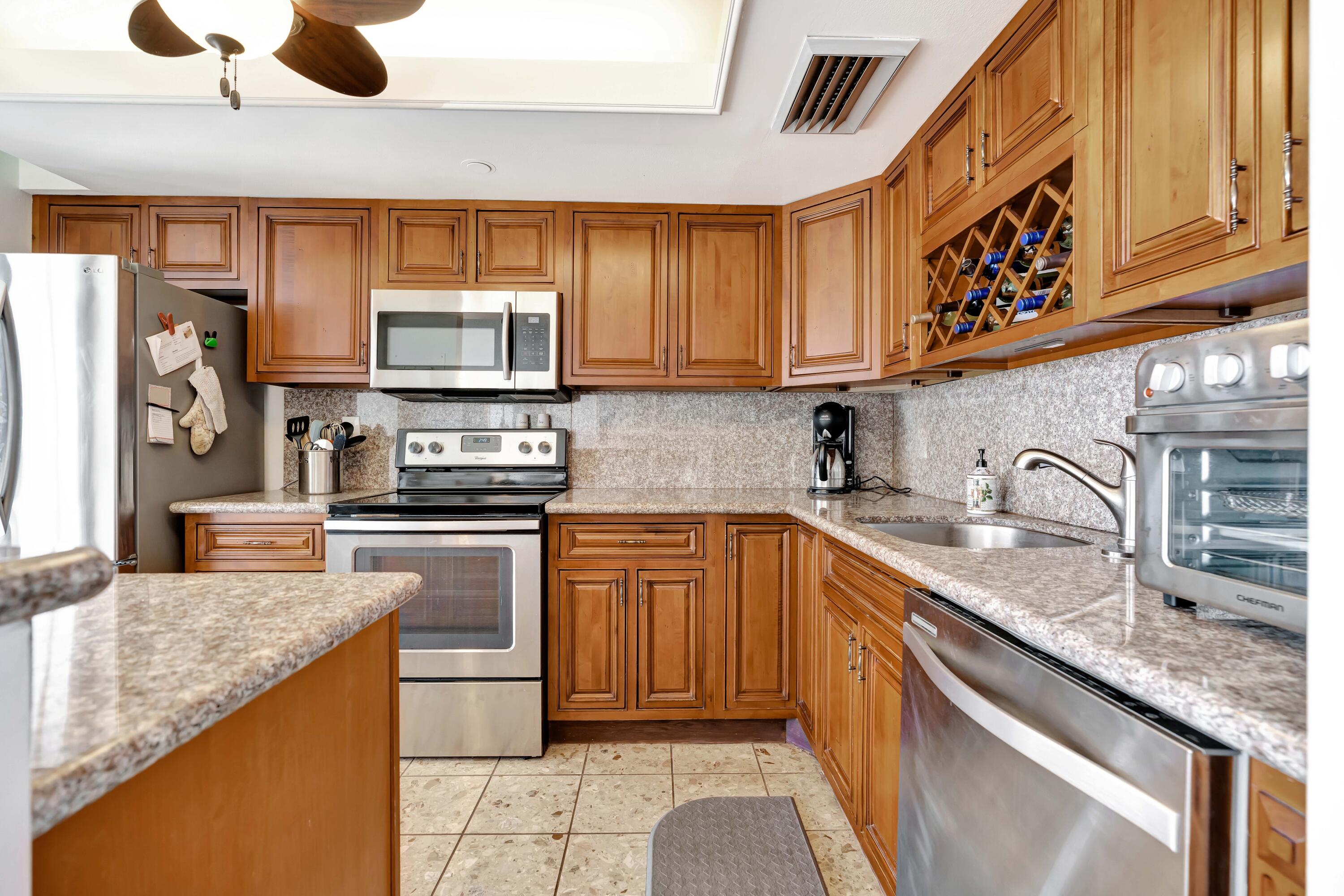 1542 Jupiter Cove Drive, Unit 104 Jupiter, FL 33469 - Photo 15 of 65 a kitchen with stainless steel appliances granite countertop a sink stove and refrigerator