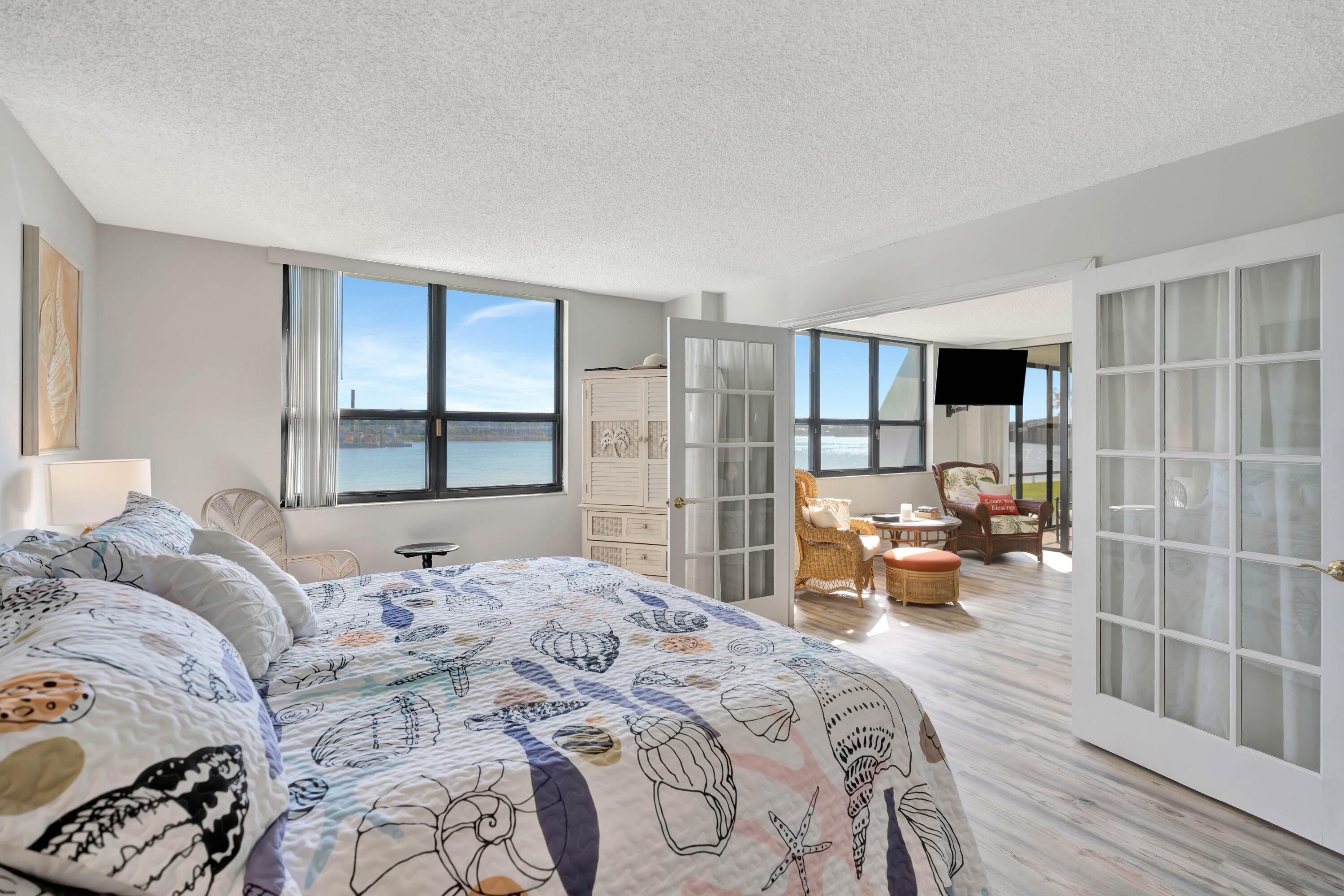 1542 Jupiter Cove Drive, Unit 104 Jupiter, FL 33469 - Photo 29 of 65 a bedroom with a large bed and a wooden floor