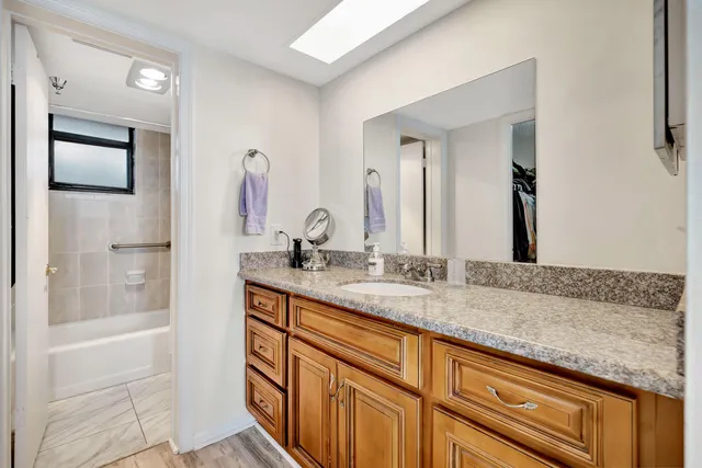 a en suite bathroom with a granite countertop sink and a mirror