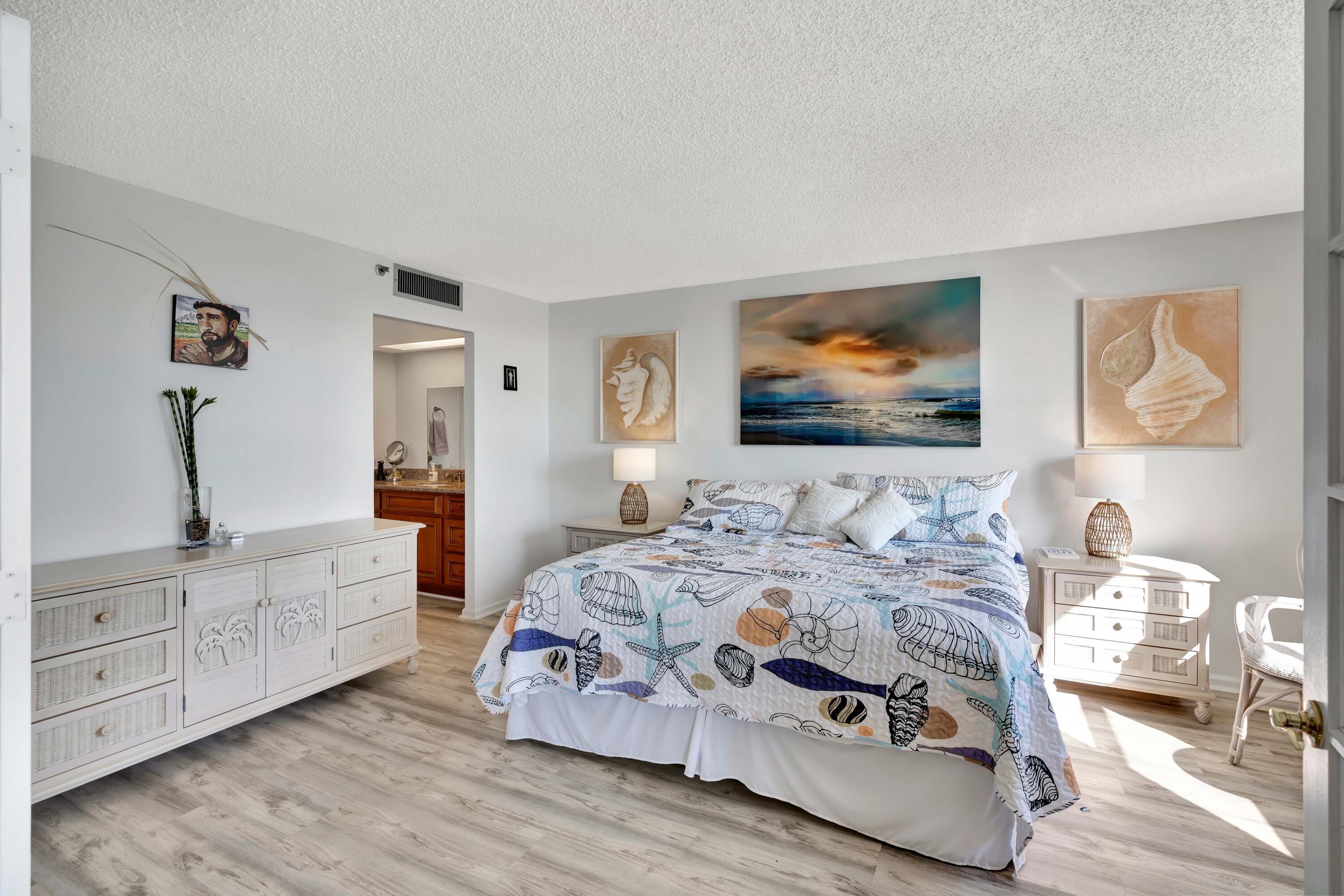 1542 Jupiter Cove Drive, Unit 104 Jupiter, FL 33469 - Photo 35 of 65 a bedroom with a bed and a chandelier