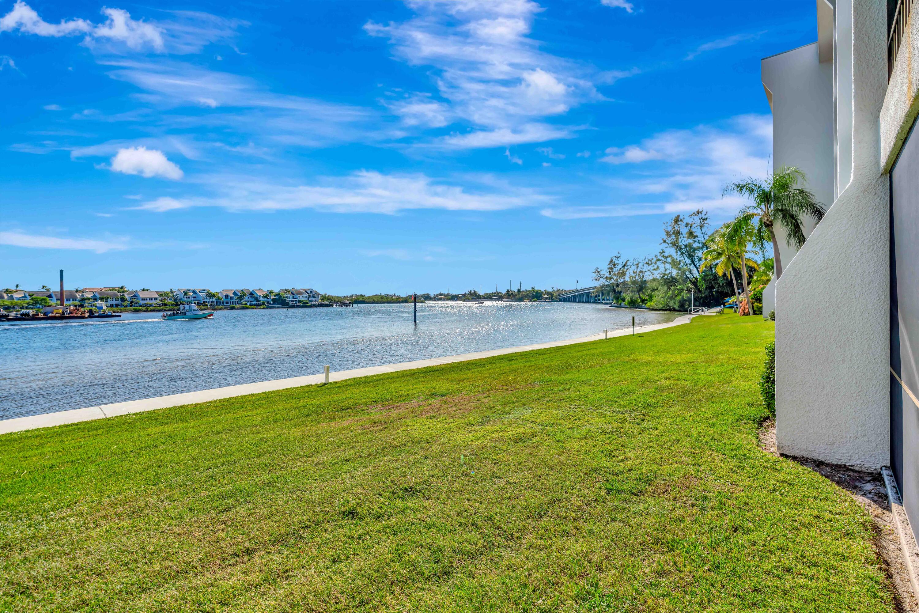 1542 Jupiter Cove Drive, Unit 104 Jupiter, FL 33469 - Photo 38 of 65 a view of a lake with houses in the back