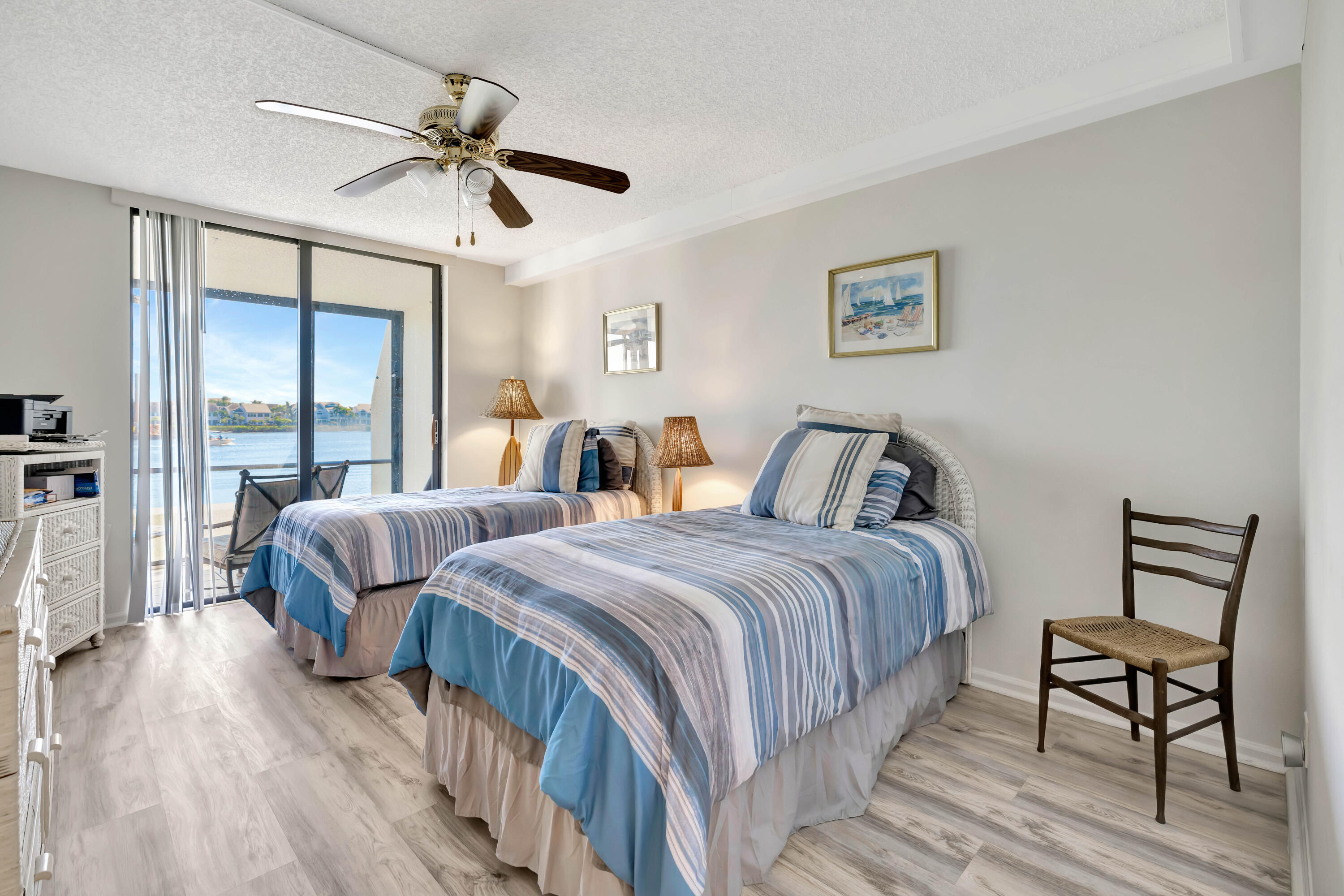 1542 Jupiter Cove Drive, Unit 104 Jupiter, FL 33469 - Photo 39 of 65 a bedroom with two beds and a chandelier