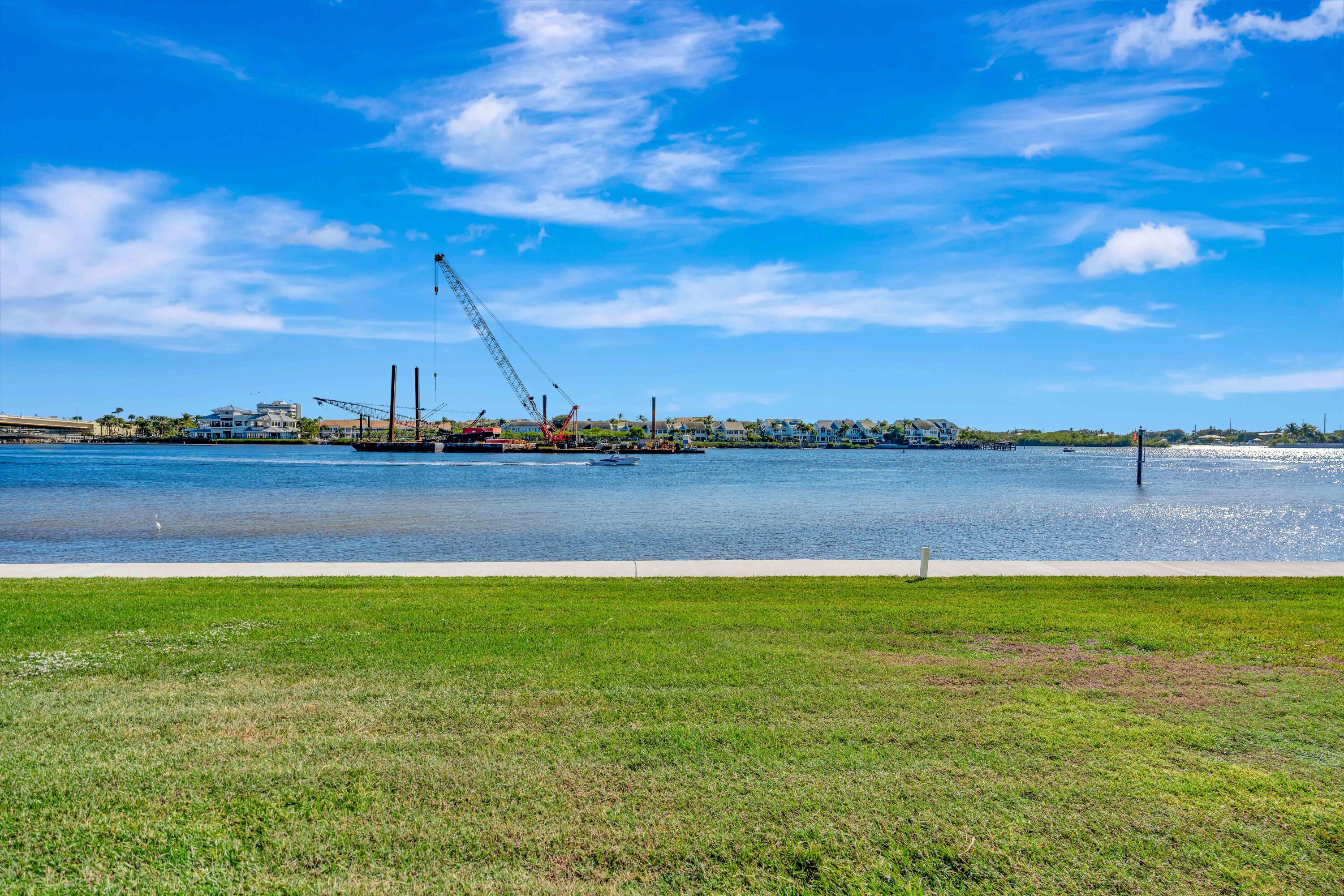 1542 Jupiter Cove Drive, Unit 104 Jupiter, FL 33469 - Photo 46 of 65 a view of a lake with houses in the back