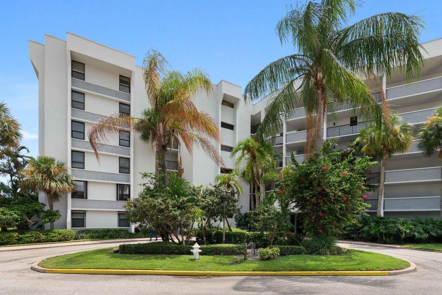 1542 Jupiter Cove Drive, Unit 104 Jupiter, FL 33469 - Photo 57 of 65 a front view of multi story residential apartment building with yard and green space