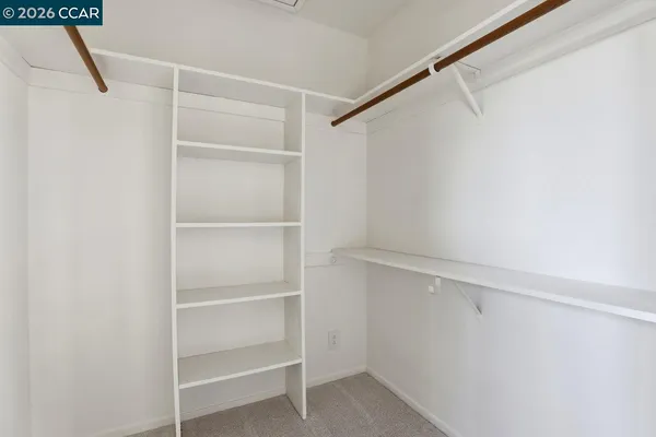 a view of walk in closet with empty racks