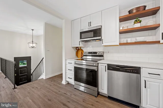 a kitchen with stainless steel appliances a stove microwave and sink