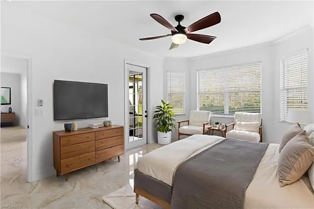 a bedroom with a bed a flat screen tv and a couch