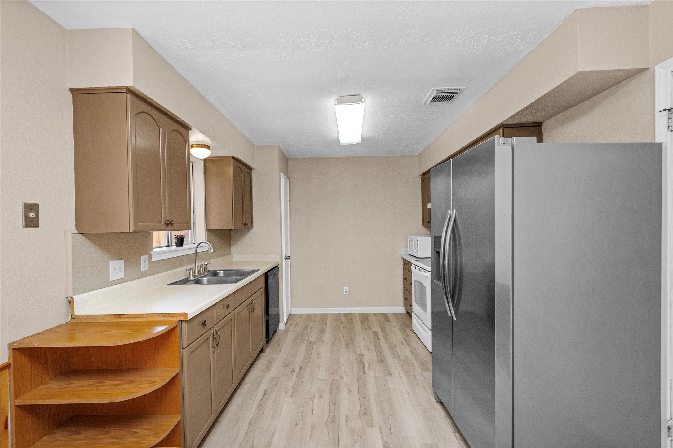 23014 Berry Pine Drive Spring, TX 77373 - Photo 11 of 29 Kitchen offers ample counter space, double stainless sink with window looking into the backyard and electric range just behind.