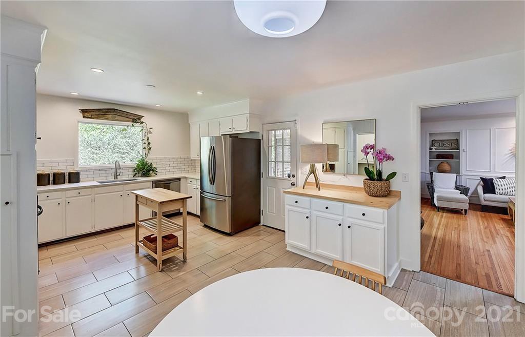 6119 Glenridge Road Charlotte, NC 28211 - Photo 14 of 41 a kitchen with sink a refrigerator and chairs