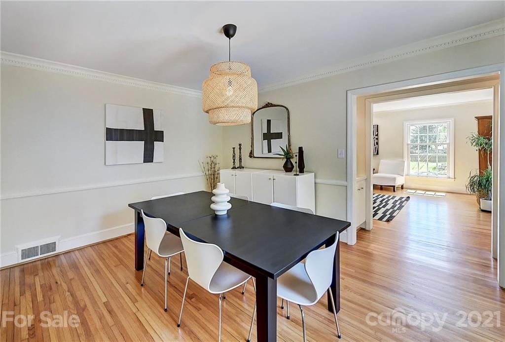 6119 Glenridge Road Charlotte, NC 28211 - Photo 10 of 41 a view of a dining room and livingroom with furniture wooden floor a chandelier