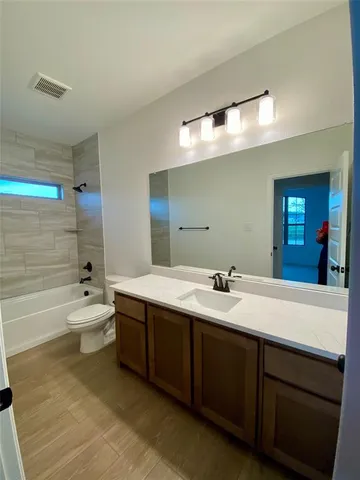 a bathroom with a bathtub double vanity sink and mirror