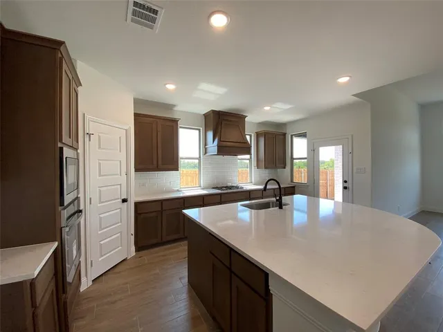 a kitchen with stainless steel appliances granite countertop a sink refrigerator and cabinets