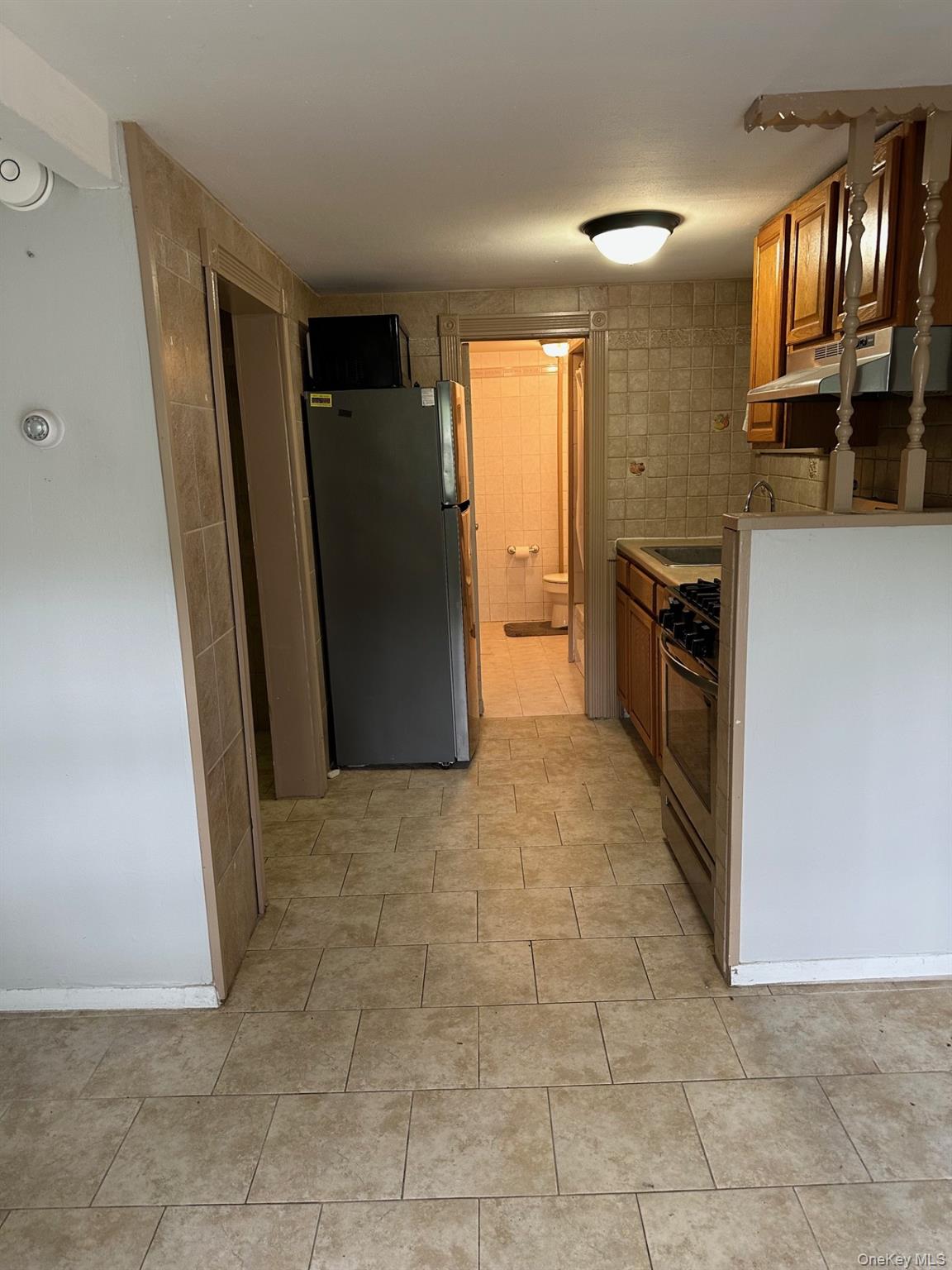 7 Yucca Road, Unit LOWR Rocky Point, NY 11778 - Photo 5 of 11 a view of a kitchen with a refrigerator