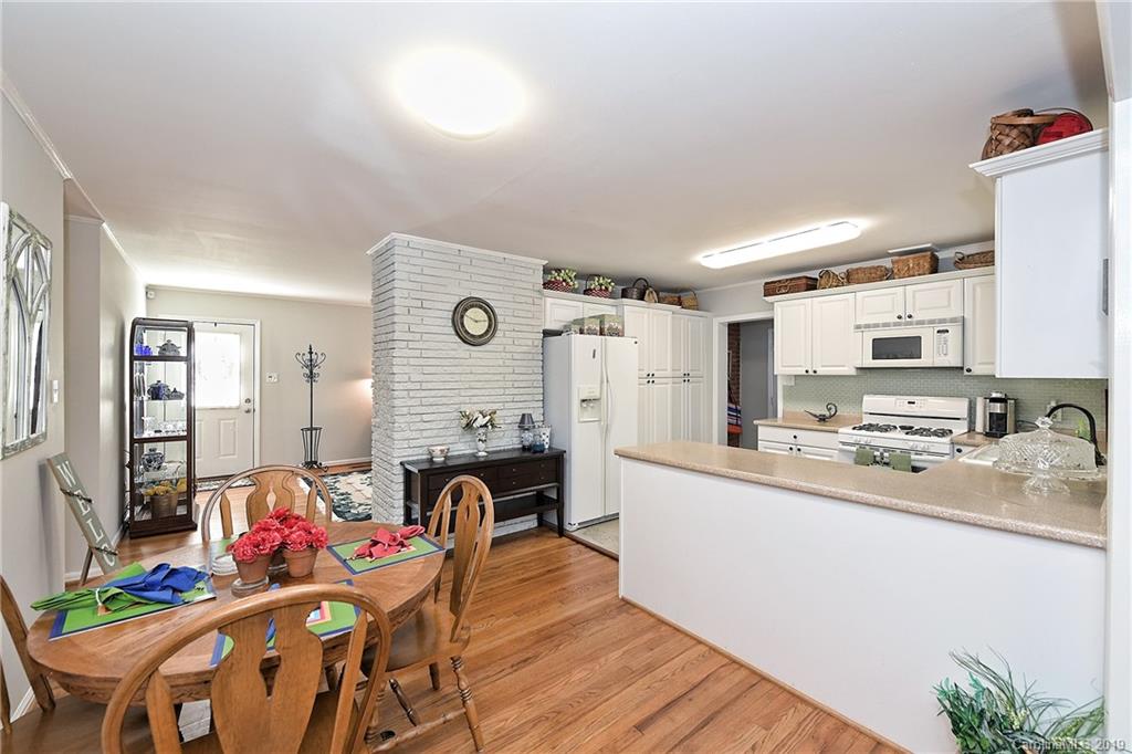725 Lochridge Road Charlotte, NC 28209 - Photo 8 of 25 a kitchen with stainless steel appliances granite countertop a refrigerator a stove top oven a sink dishwasher and white cabinets with wooden floor