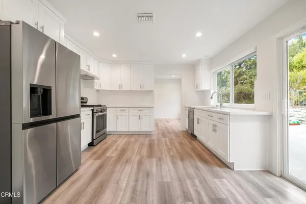a kitchen with stainless steel appliances a refrigerator sink and cabinets